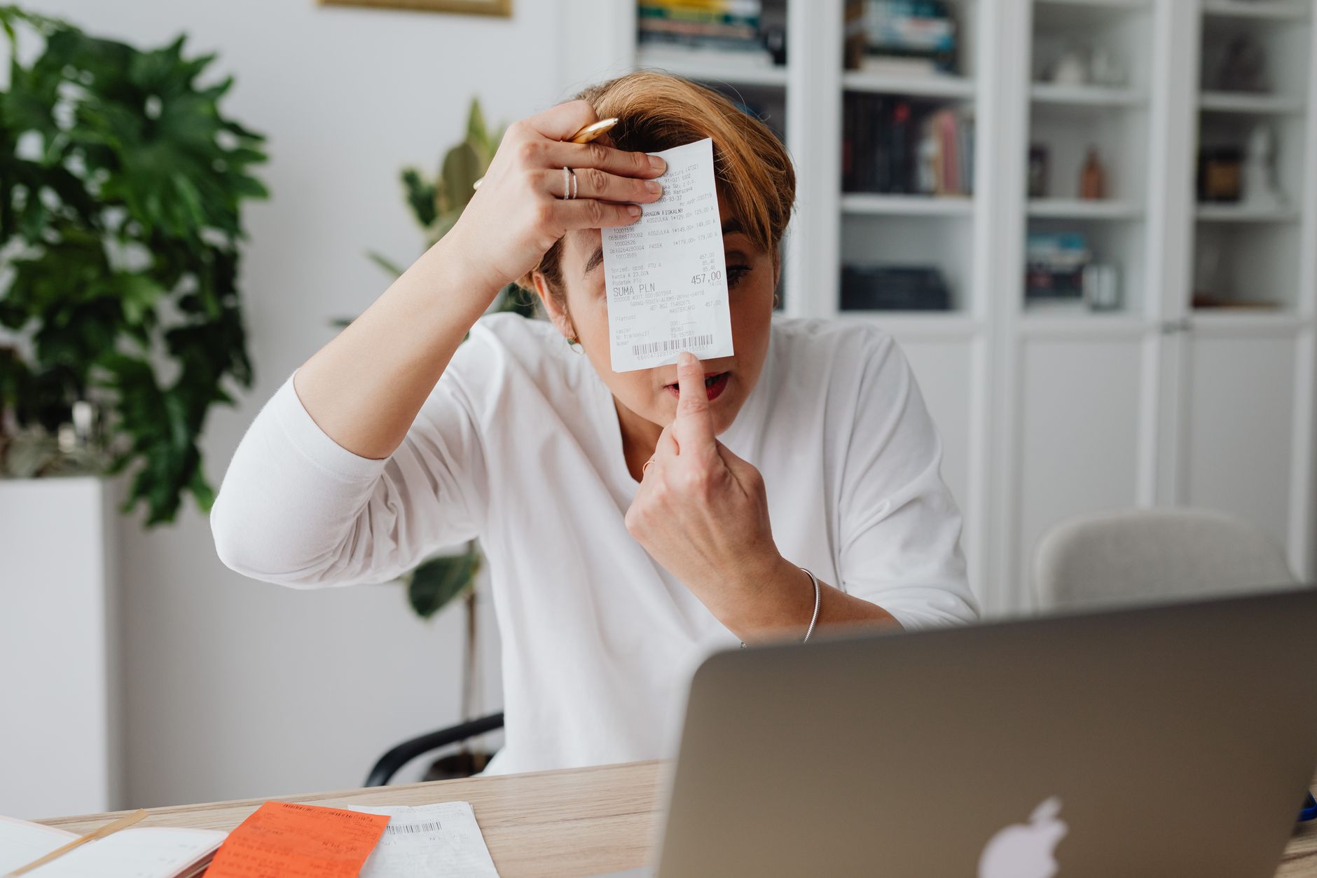 Cheffe d'entreprise consultant une facture numérique sur son ordinateur portable dans un bureau