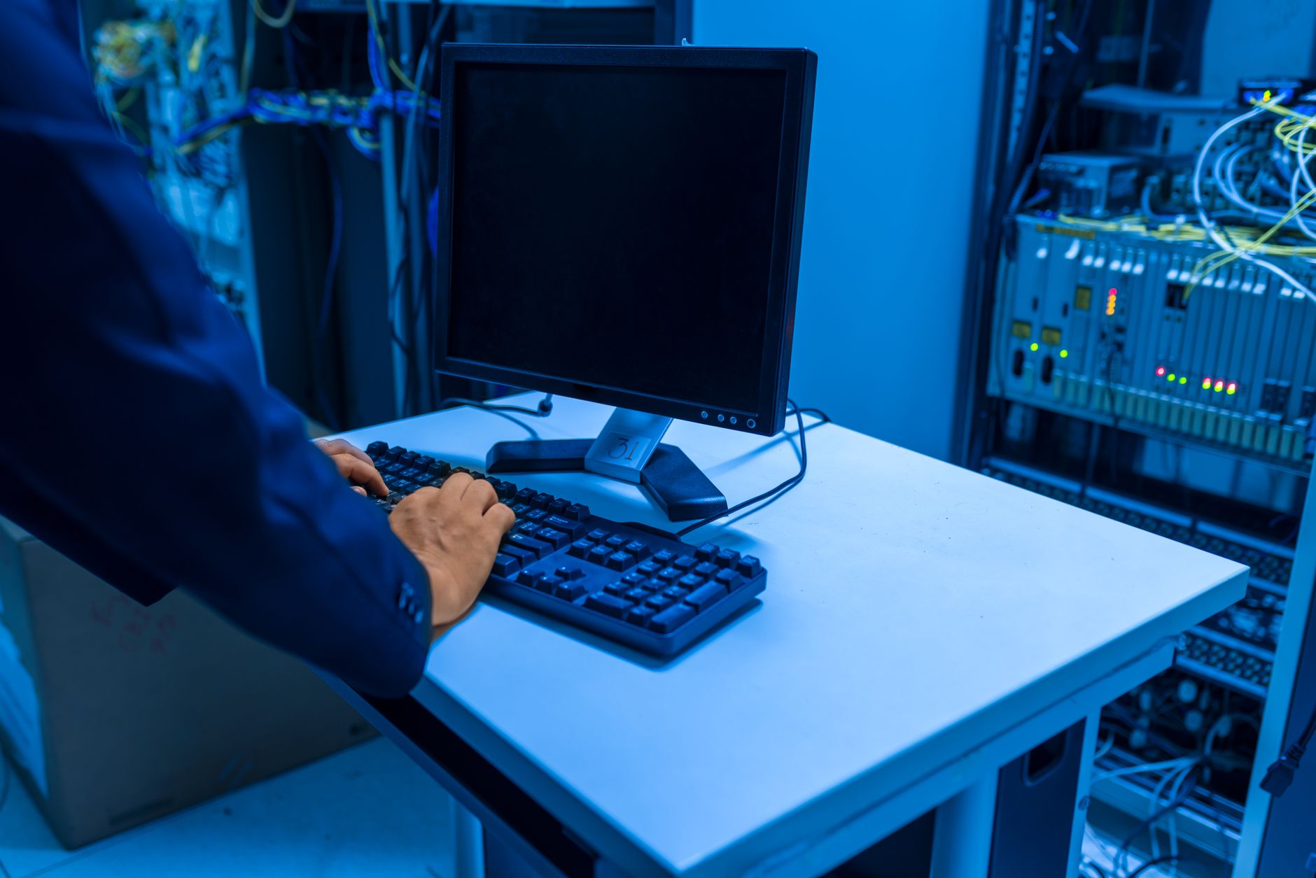 Technicien IT travaillant dans une salle serveur, gérant les systèmes d'information d'une PME