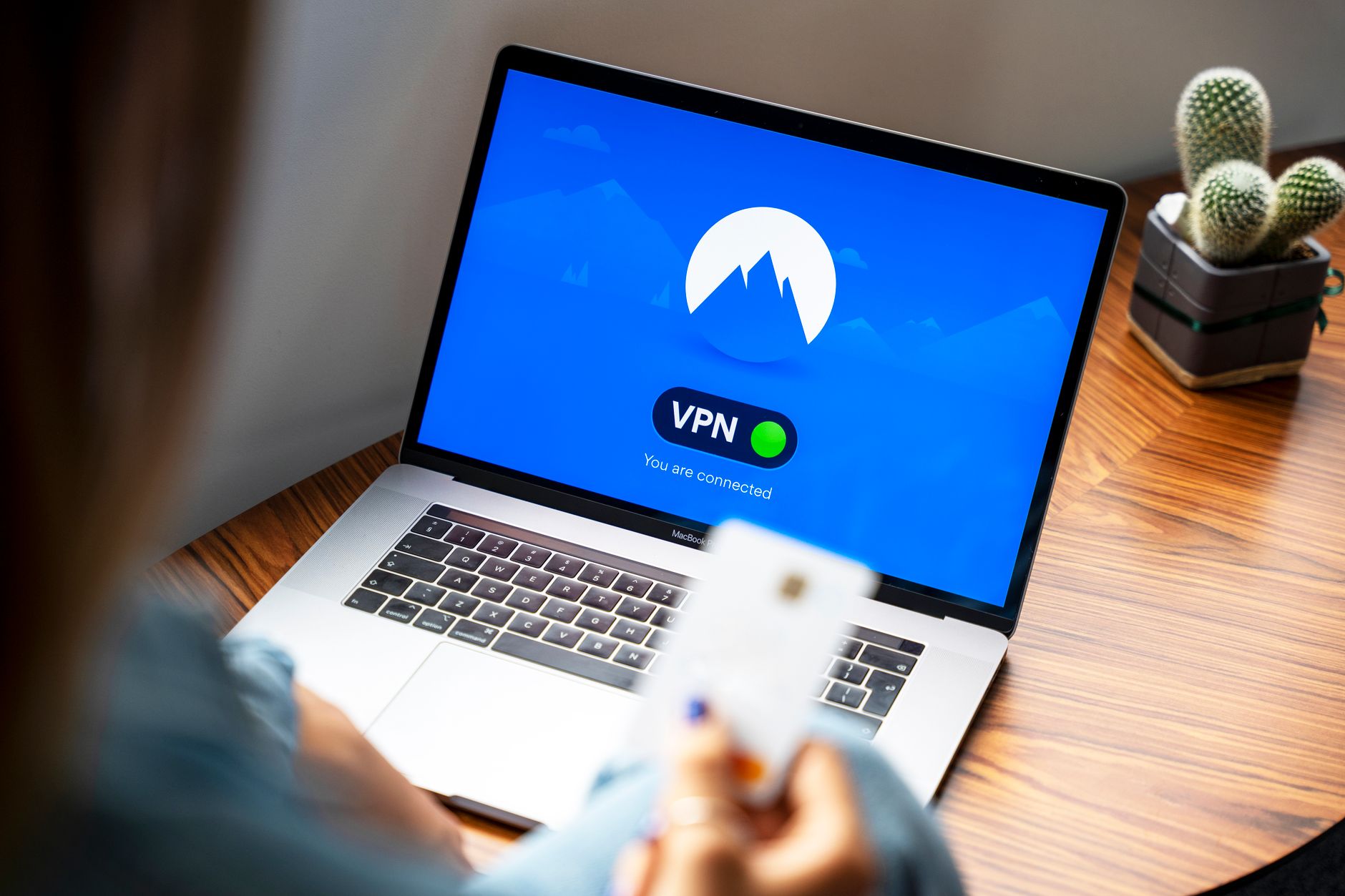 Personne utilisant un VPN sur un ordinateur portable dans un espace de travail sécurisé, illustrant la protection des accès en entreprise