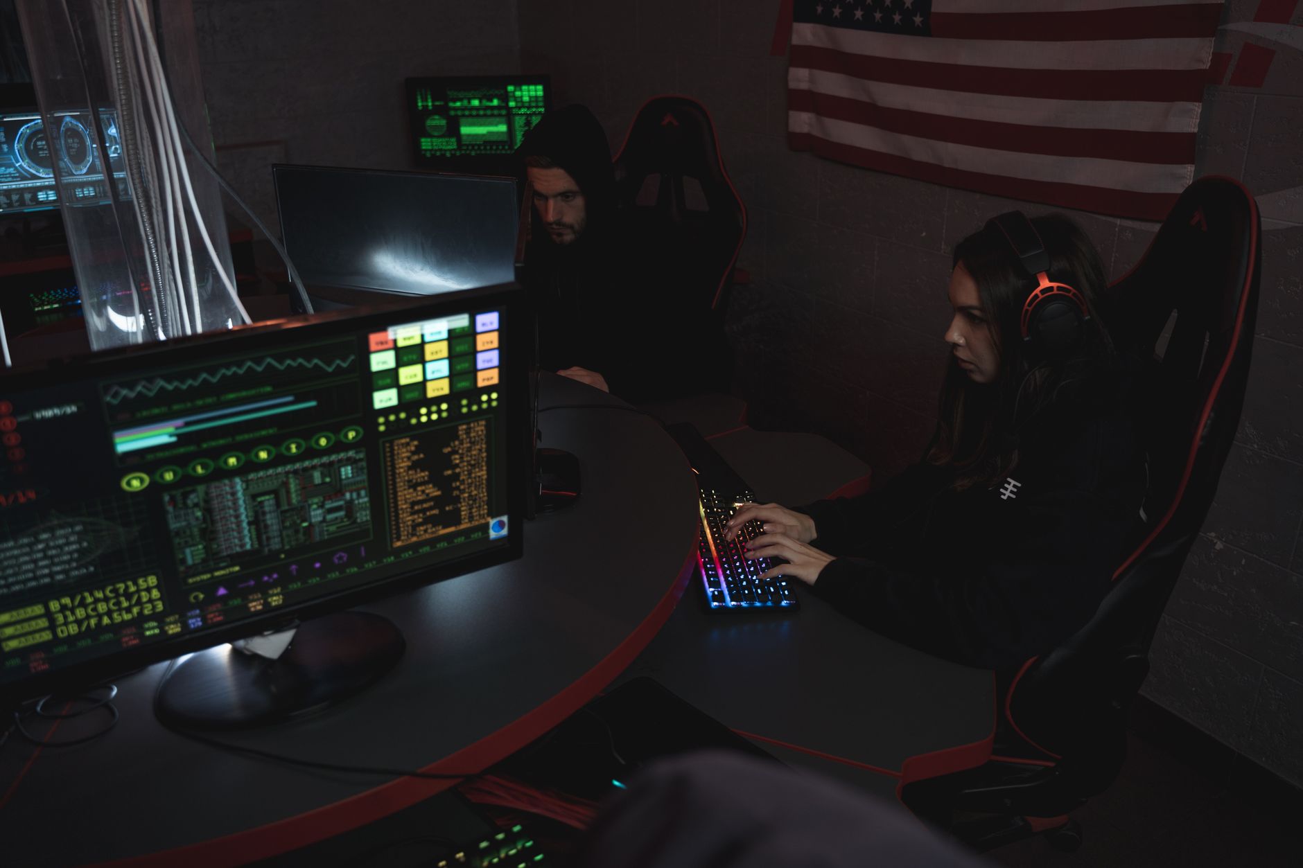 Deux experts cybersécurité analysent des alertes sur écrans de monitoring dans une salle obscure