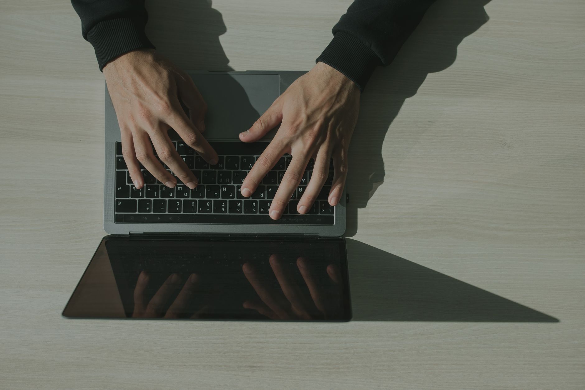Mains d'un collaborateur tapant sur un ordinateur portable dans un bureau, illustration de la messagerie professionnelle sécurisée
