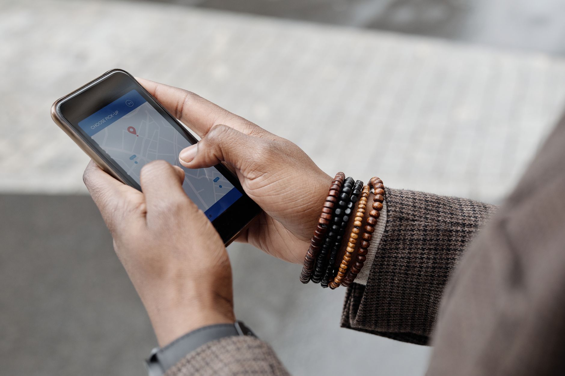 Mains tenant un smartphone affichant une carte Google Maps avec des épingles de localisation d'entreprises locales