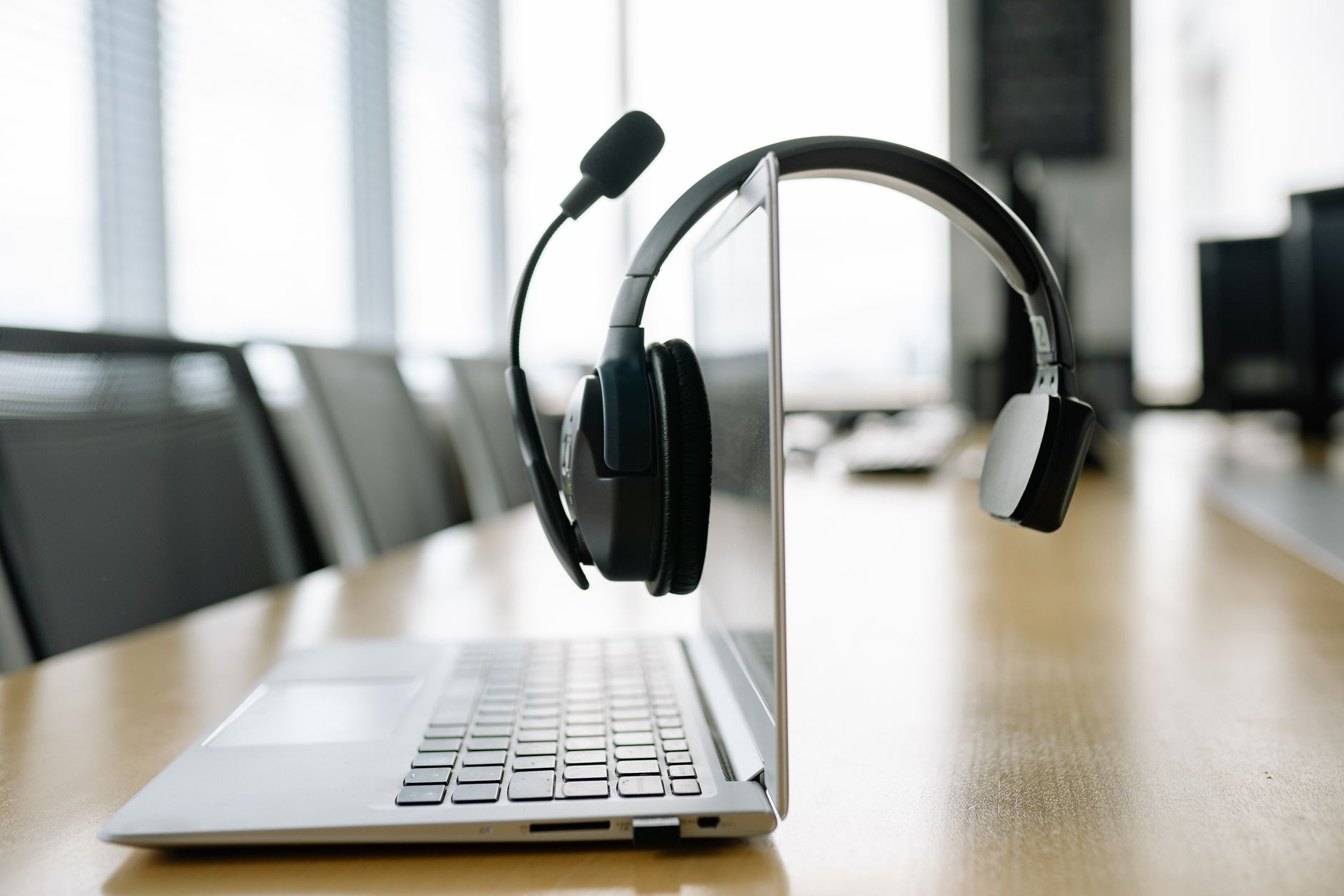 Casque VoIP professionnel posé devant un ordinateur portable dans un bureau moderne